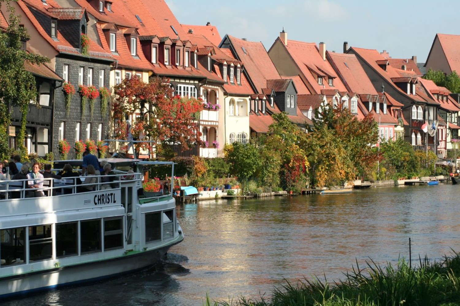 Dicht gedrängte Fachwerkhäuser aus dem Mittelalter und winzige Gärten direkt an der Regnitz: Klein Venedig mit dem Ausflugsschiff. &ndash;  (&copy;&nbsp;Bamberg Tourismus & Kongress Service)
